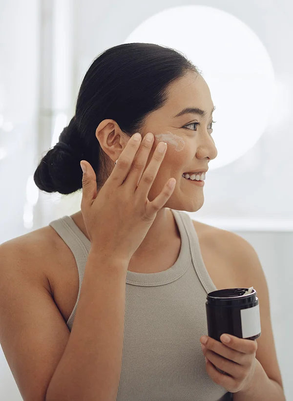 woman putting product on her face | Henderson Breast Reconstruction New York