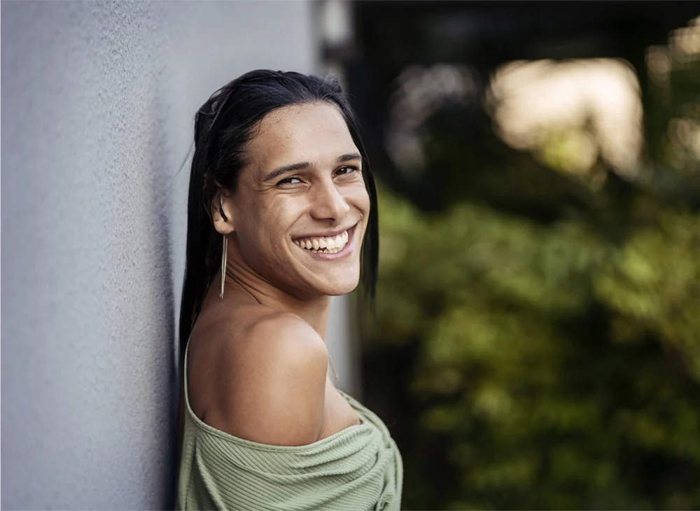 transgender woman outside standing near a wall | Henderson Breast Reconstruction New York